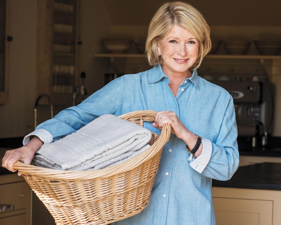 Martha holding a laundry basket, smiling