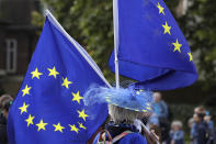 An Anti-Brexit demonstrator waves European Union flags near Parliament in London, Tuesday, Oct. 8, 2019. The British government said Tuesday that the chances of a Brexit deal with the European Union were fading fast, as the two sides remained unwilling to shift from their entrenched positions. (AP Photo/Kirsty Wigglesworth)