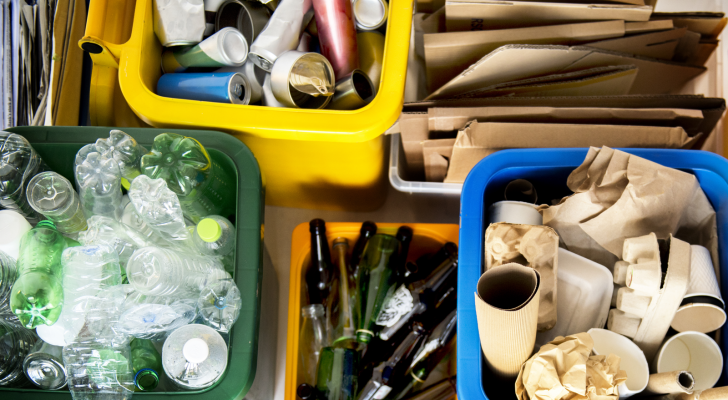 Bins are filled with various recyclibles, including cardboard, glass, and plastic