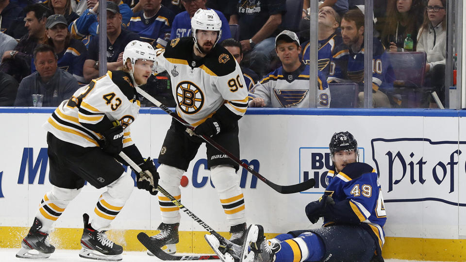 Boston Bruins center Danton Heinen (43) and left wing Marcus Johansson (90), of Sweden, battle for the puck with St. Louis Blues center Ivan Barbashev (49), of Russia, during the first period of Game 3 of the NHL hockey Stanley Cup Final Saturday, June 1, 2019, in St. Louis. (AP Photo/Jeff Roberson)