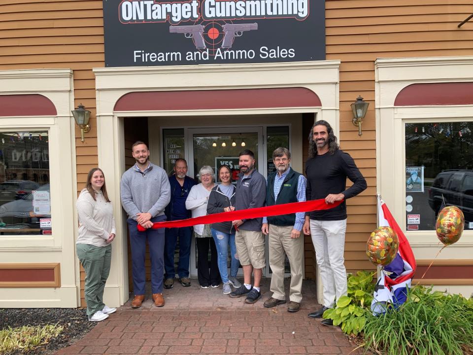 Pictured from left to right are Rebecca Lapierre Town Square Realty, Alex Shain Partners Bank, Roland and Joyce Fogg, Owners of ONTarget Gunsmithing Jess and Rob Libby, Rick Stanley Chamber President and Dan Bowden Pilots Cove Café’.