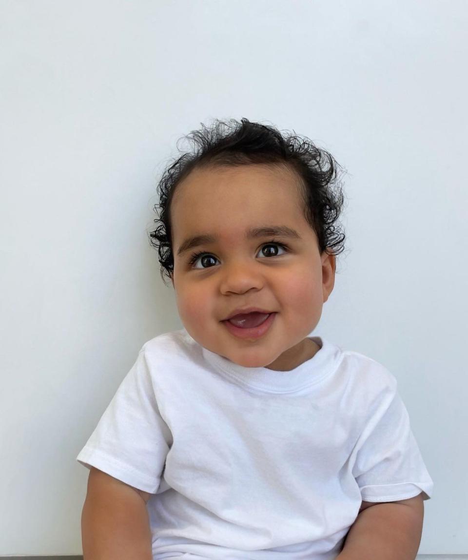 Khloe Kardashian's son, Tatum, smiling in a white T-shirt