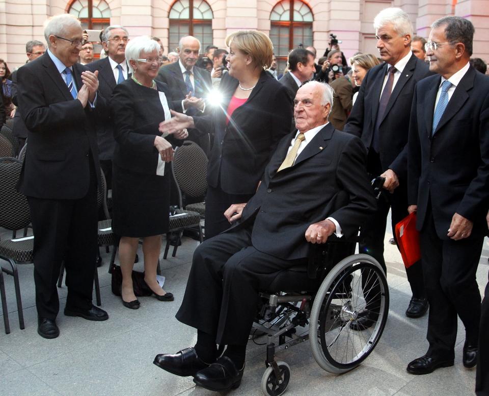 <p>Angela Merkel überreicht Kohl eine Sonderbriefmarke anlässlich des 30. Jahrestages seiner Wahl. Die Marke enthält die Aufschrift „Kanzler der Einheit” und „Ehrenbürger Europas”. (Bild: AP Photo/Wolfgang Kumm, pool) </p>