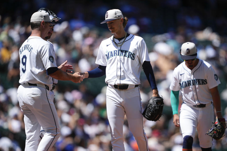 Seattle Mariners manager Scott Servais (9) arrives on the mound to pull starting pitcher Bryce Miller, center, against the Baltimore Orioles during the sixth inning of a baseball game Thursday, July 4, 2024, in Seattle. (AP Photo/Lindsey Wasson)