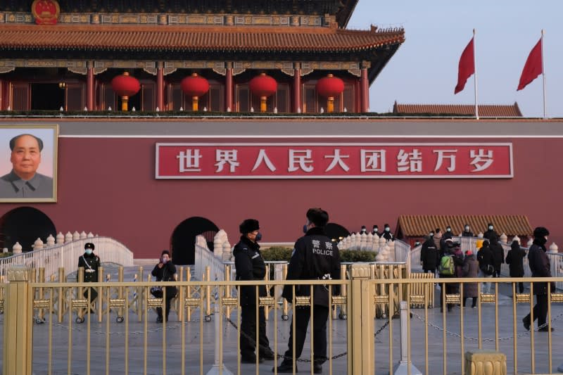 Police officers wearing protective masks are seen in front of the Tiananmen Gate in Beijing