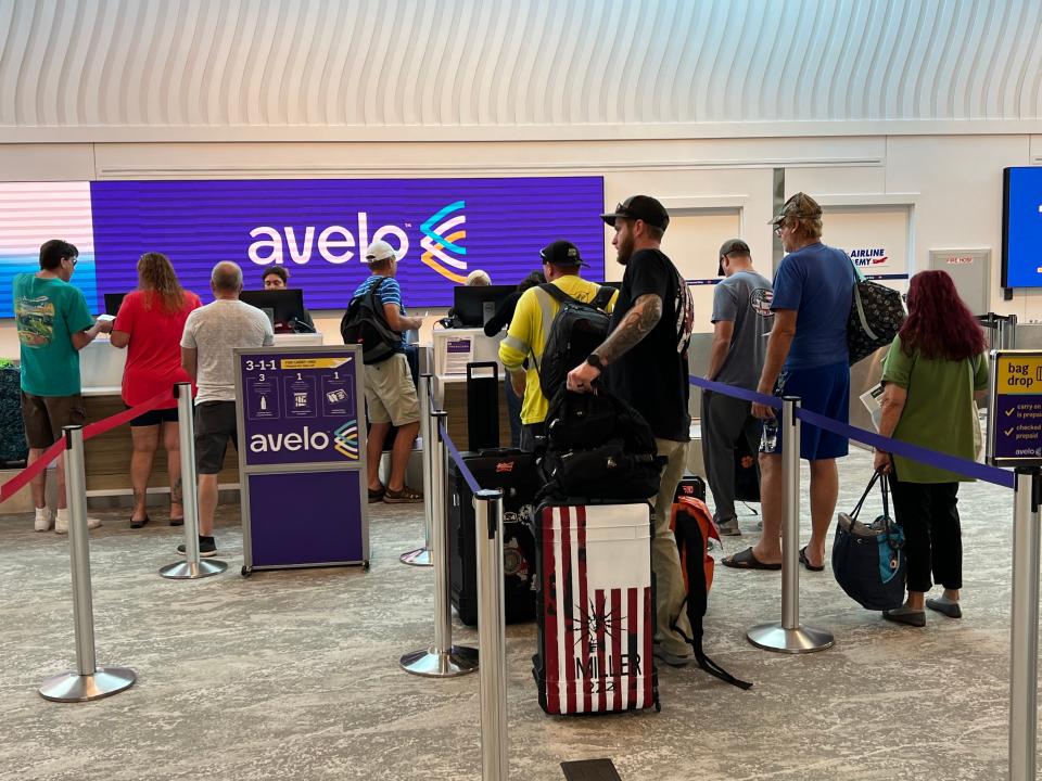 Air travelers check in at the ticket counter for Avelo Airlines at Daytona Beach International Airport to catch a departing nonstop flight to New Haven, Connecticut, on Thursday, Sept. 14, 2023.