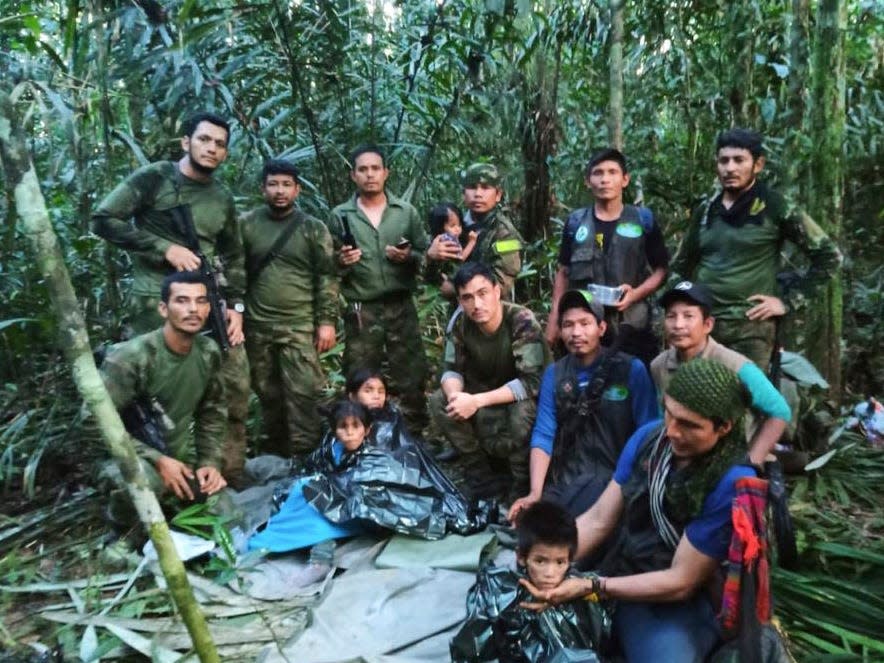 Soldiers and Indigenous men pose for a photo with the four Indigenous brothers