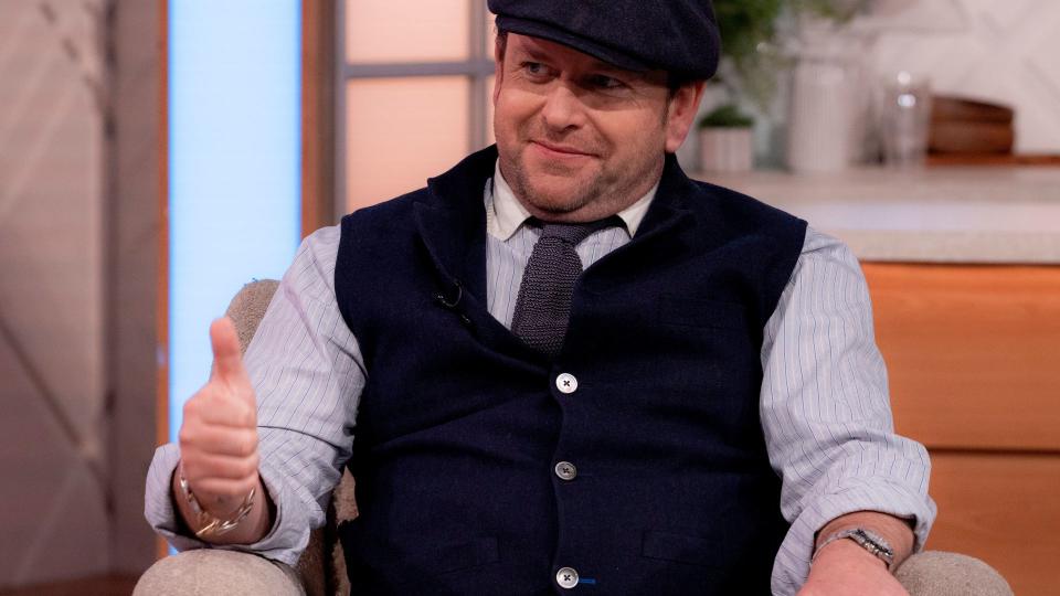 man wearing waistcoat and flat cap 