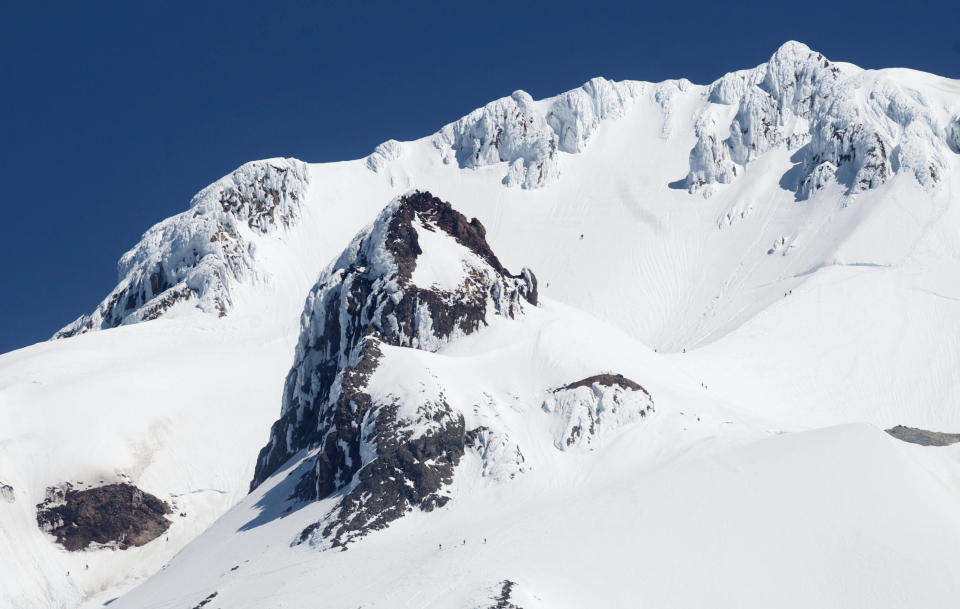 This photo taken Thursday, June 14, 2012 shows the area of Mount Hood where experienced climber Mark Cartier fell to his death earlier in the day. Cartier fell to the left, off of Hogsback, the u-shaped ridge on the right of the frame, and behind the large rock, Crater Rock, in center of photo. (AP Photo/The Oregonian, Brent Wojahn)