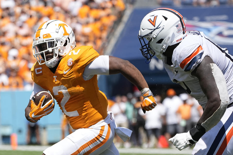 Tennessee running back Jabari Small (2) rushes past Virginia defensive end Ben Smiley III, left, in the first half of an NCAA college football game Saturday, Sept. 2, 2023, in Nashville, Tenn. (AP Photo/George Walker IV)