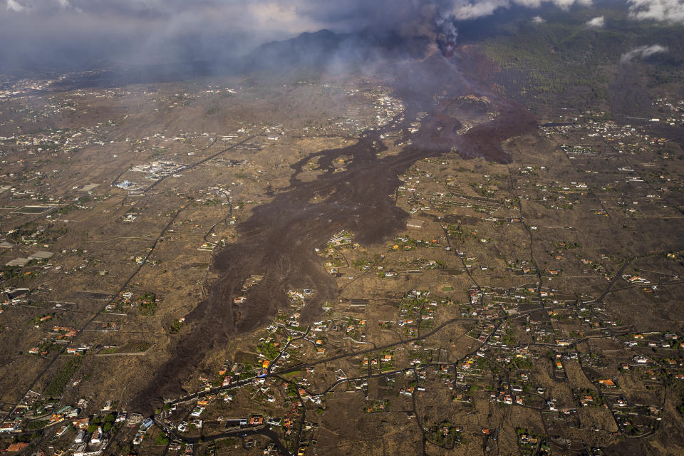 FILE - Lava from a volcano eruption flows on the island of La Palma in the Canaries, Spain, Thursday, Sept. 23, 2021. A six-kilometer-long black lava scar crossing Spain's La Palma island remains as testimony to the three-month-long eruption that left no casualties but wreaked havoc in the lives of many when it struck a year ago. Many islanders feel forgotten and victims mark the first anniversary Monday, Sept. 19, 2022, with a demonstration to protest the management of the emergency. (AP Photo/Emilio Morenatti, Pool, File)
