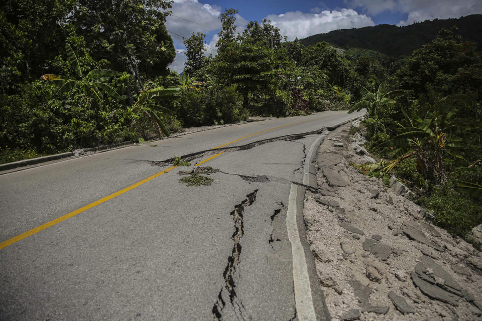 A road is seen damaged by the earthquake in Camp-Perrin, Les Cayes, Haiti, Sunday, Aug. 15, 2021. The death toll from the magnitude 7.2 earthquake in Haiti soared on Sunday as rescuers raced to find survivors amid the rubble ahead of a potential deluge from an approaching tropical storm. (AP Photo/Joseph Odelyn)