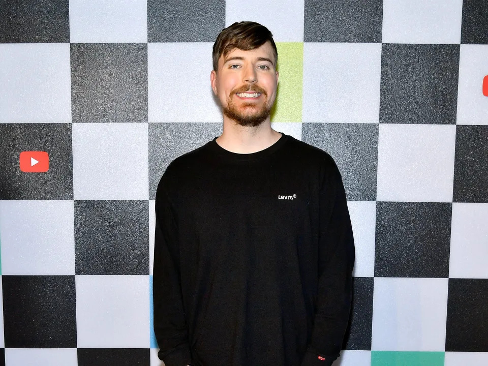 MrBeast smiling in front of checkered background at YouTube Broadcast event.