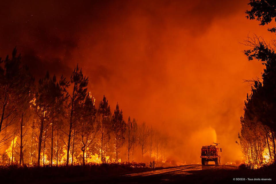 This photo provided by the fire brigade of the Gironde region SDIS 33, (Departmental fire and rescue service 33) shows firefighters tackling a blaze near Saint-Magne, south of Bordeaux, southwestern France, Wednesday, Aug. 10, 2022. (SDIS 33 via AP)