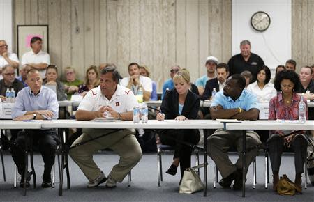 New Jersey Gov. Chris Christie, (2nd L), talks to business owners affected by a massive fire that burned a large portion of the Seaside Park boardwalk in Seaside Heights, N.J. September 14, 2013. REUTERS/Julio Cortez/Pool