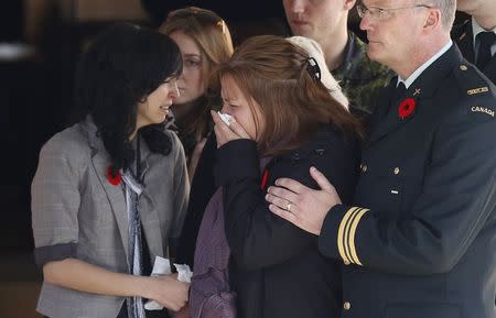 Kathy Cirillo (C), the mother of Cpl. Nathan Cirillo, reacts as his casket is placed in a hearse at a funeral home in Ottawa October 24, 2014. REUTERS/Chris Wattie