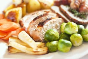 Christmas turkey dinner with Brussels sprouts, parsnips, carrots, roast potatoes, stuffing and pigs in blankets (sausages wrappe