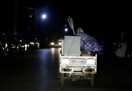 A migrant worker rides a tricycle filled with luggage as he was forced to move out of his apartment before midnight at a village outside the sixth ring road in Tongzhou district of Beijing, China, November 23, 2017. Picture taken November 23, 2017. REUTERS/Jason Lee