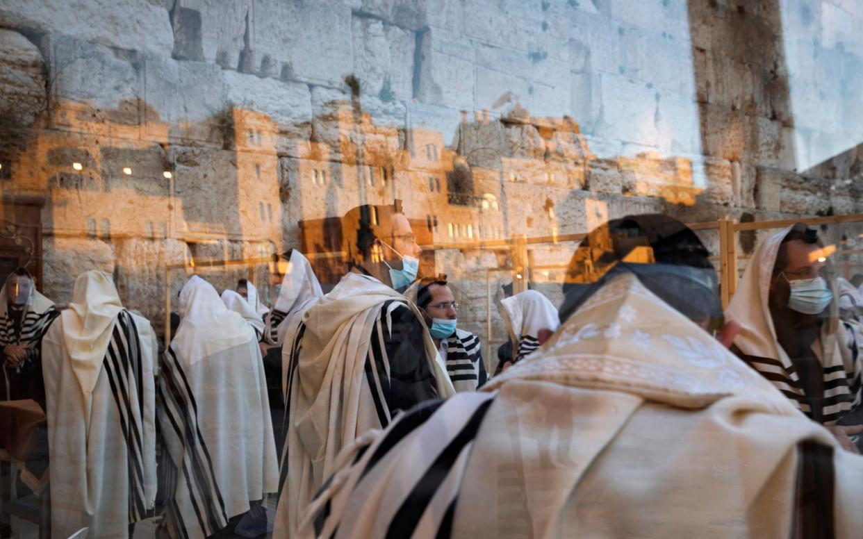 Ultra-Orthodox Jewish men pray in a divided section during nationwide lockdown due to the coronavirus pandemic at the Western Wall - AP