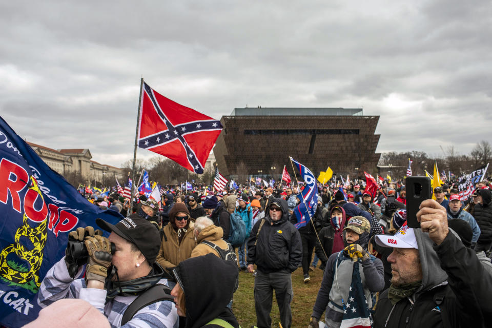 Un hombre enarbola la bandera confederada, con el Museo Nacional de Historia y Cultura Afroestadounidense de fondo, mientras el presidente Donald Trump se dirige a la multitud en Washington, el 6 de enero de 2021. (Jason Andrew/The New York Times)