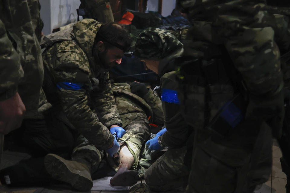 Ukrainian servicemen administer first aid to a wounded soldier in a shelter in Soledar. (Getty)