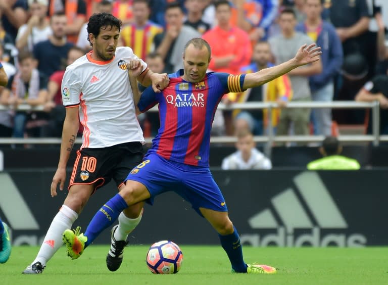 Valencia's midfielder Dani Parejo (L) vies with Barcelona's midfielder Andres Iniesta during the Spanish league football match between Valencia CF and FC Barcelona at the Mestalla stadium in Valencia on October 22, 2016