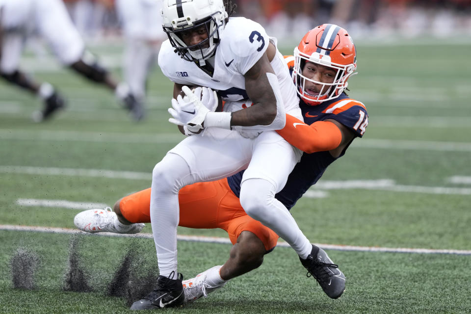 FILE - Penn State wide receiver Dante Cephas carries the ball after a reception as Illinois defensive back Xavier Scott makes the tackle during an NCAA college football game Sept. 16, 2023, in Champaign, Ill. A half-century ago, there were 74 schools at the top level of college football playing on natural grass and the number actually peaked around 20 years ago at 75. It has plummeted since, even with more and more money flowing into Power Five school coffers from billion-dollar TV contracts. (AP Photo/Charles Rex Arbogast, File)