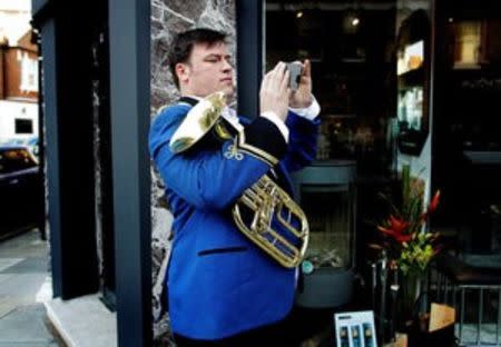 A man photographs a Remembrance Sunday parade through Fulham in West London, Britain November 13, 2011. REUTERS/Kevin Coombs