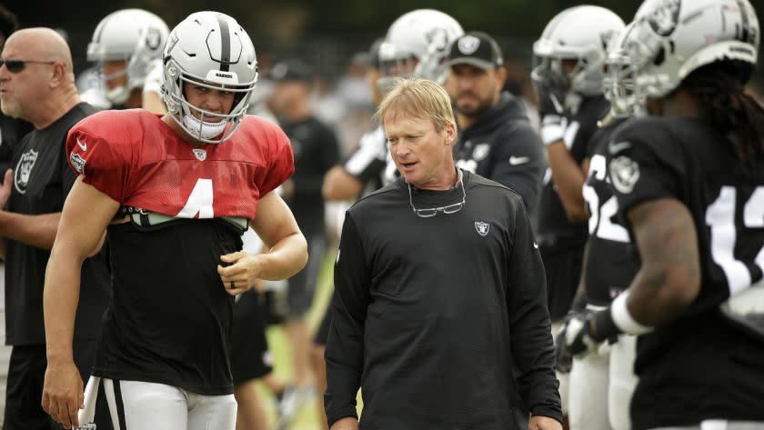 Oakland Raiders head coach Jon Gruden talks with quarterback Derek Carr during NFL football practice Wednesday, Aug. 8, 2018, in Napa, Calif. Both the Oakland Raiders and the Detroit Lions held a joint practice before their upcoming preseason game on Friday. (AP Photo/Eric Risberg)