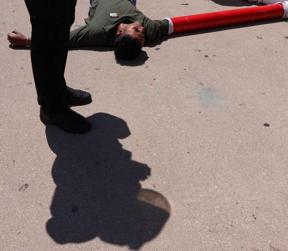 About seven people were detained and lay on the hot sidewalk after blocking the intersection of 3rd Street and northbound Biscayne on Monday, April 15, 2024, in downtown Miami, Florida. Carl Juste/cjuste@miamiherald.com