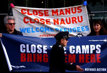 Refugee advocates hold signs as they protest against the detention of asylum seekers being held at Australian-run offshore detention centers located on Papua New Guinea's Manus Island, and the South-Pacific island of Nauru, in central Sydney, Australia, August 31, 2017. REUTERS/David Gray