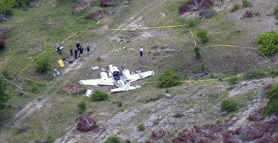 Authorities investigate at the crash scene of a twin-engine Beechcraft BE58, Monday, April 22, 2019, near Kerrville, Texas. The pilot and the five other people aboard the plane were all killed, said Sgt. Orlando Moreno, a spokesman for the Texas Department of Public Safety. (William Luther/The San Antonio Express-News via AP)