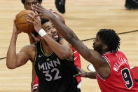 Minnesota Timberwolves center Karl-Anthony Towns, left, looks to the basket against Chicago Bulls forward Patrick Williams during the second half of an NBA basketball game in Chicago, Wednesday, Feb. 24, 2021. (AP Photo/Nam Y. Huh)