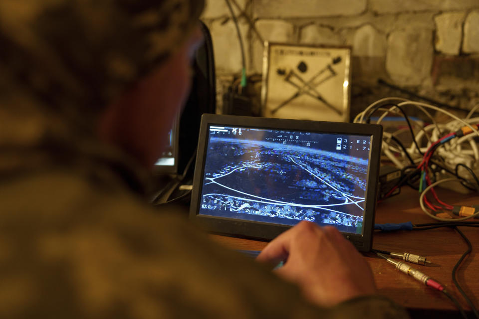 A Ukrainian serviceman of the ACHILLES battalion of the 92nd brigade looks at a screen during the flight of a suicide drone over Russian positions in the Kharkiv region of Ukraine on Sunday, May 12, 2024. (AP Photo/Evgeniy Maloletka)