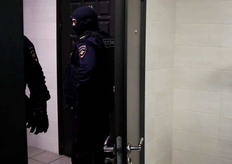 Law enforcement officers stand outside an apartment of Russian opposition leader Alexei Navalny in Moscow