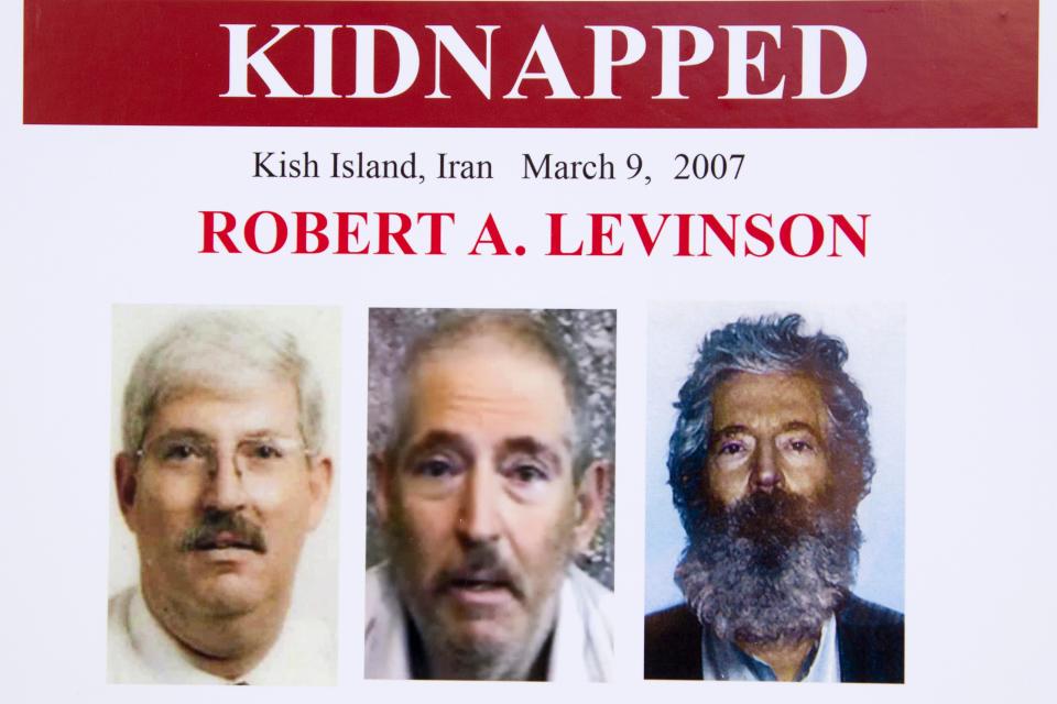 FILE - In this March 6, 2012, file photo, an FBI poster showing a composite image of former FBI agent Robert Levinson, right, of how he would look like now after five years in captivity, and an image, center, taken from the video, released by his kidnappers, and a picture before he was kidnapped, left, displayed during a news conference in Washington. A federal judge has held Iran responsible for the kidnapping of former FBI agent Robert Levinson. U.S. District Judge Timothy Kelly entered a default judgement against the regime on the 13th anniversary on his disappearance. (AP Photo/Manuel Balce Ceneta, File)