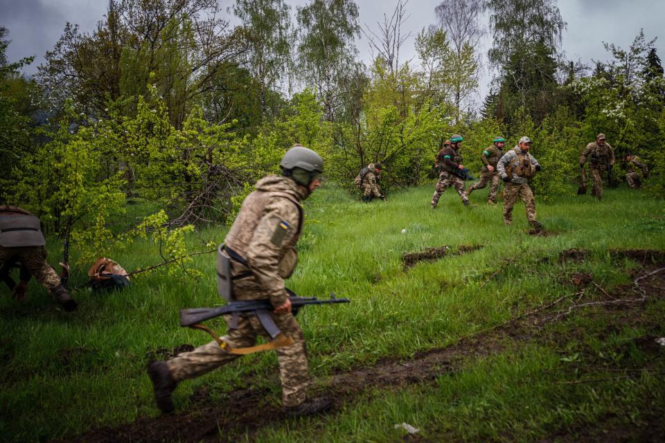 Ukrainian servicemen run to take cover during shelling near the frontline city of Bakhmut, Donetsk region on April 30, 2023, amid the Russian invasion of Ukraine.