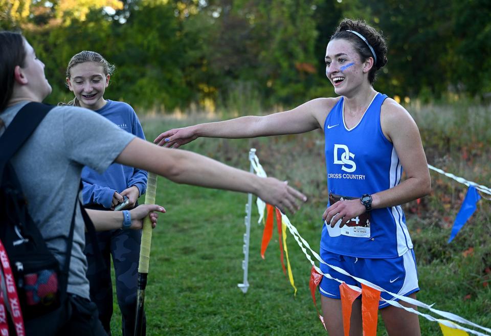 Dover-Sherborn junior Margaret Bowles is elated after winning the girls race against Norton with a course record of 16:33, smashing the previous 9-year-old record by eight seconds,  at Dover-Sherborn Regional High School in Dover, Oct. 6, 2022. The Raiders won the final home meet of the season to remain undefeated at 4-0. 