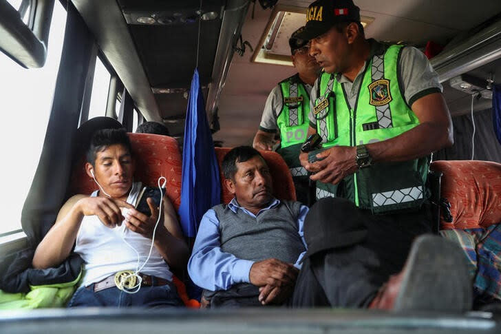 Foto del martes de agentes de la policía de Perú pidiendo identificaciones a pasajeros en las afueras de Lima