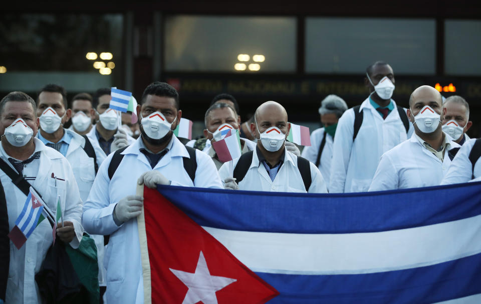 Médicos y paramédicos de Cuba posan a su llegada al aeropuerto Malpensa de Milán, Italia, el domingo 22 de marzo de 2020, para ayudar en la atención a los enfermos de COVID-19. (AP Foto / Antonio Calanni)