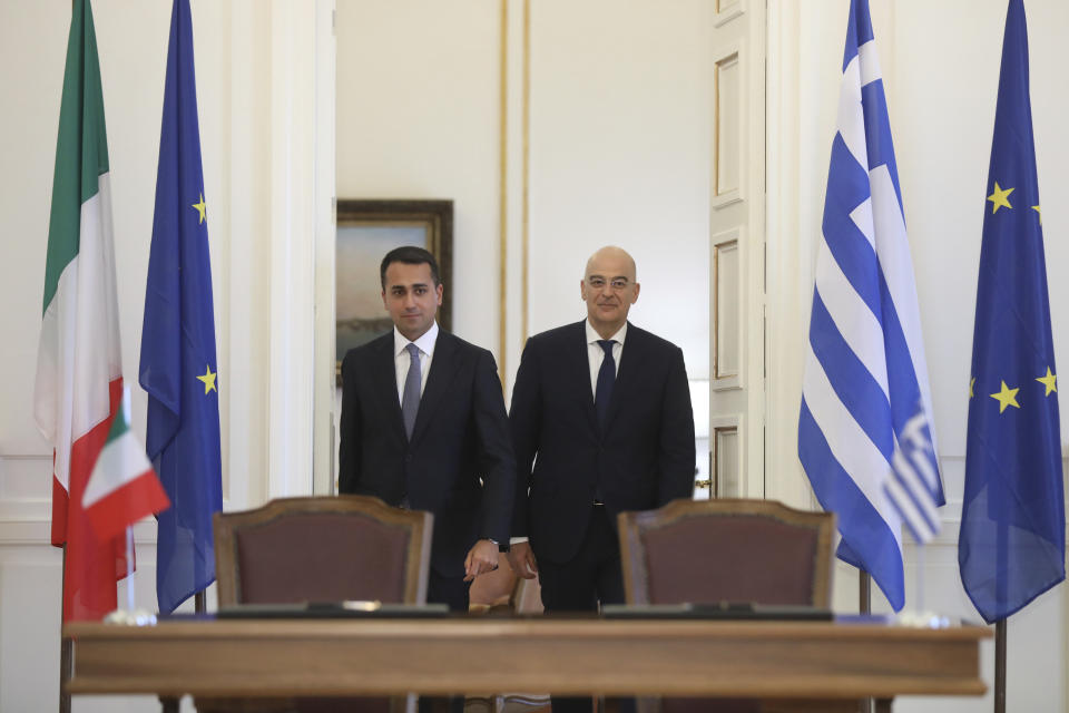 Greek Foreign Minister Nikos Dendias, right, and his Italian counterpart Luigi Di Maio arrive to sign an agreement following their meeting , in Athens, on Tuesday, June 9, 2020. Greece will lift all restrictions on Italian tourists entering the country gradually between June 15 and the end of the month, Greece's foreign minister said Tuesday.(Costas Baltas /Pool via AP)