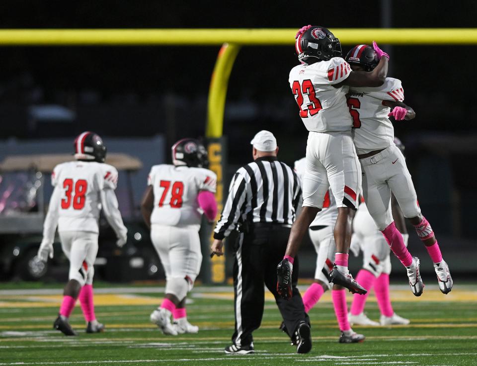 Aliquippa's Tiqwai Hayes (23) celebrates with John Tracy (6) after Tracy ran back the opening kickoff for a touchdown during Friday night's game at Blackhawk High School.