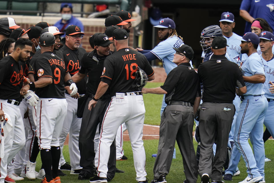 Baltimore Orioles manager Brandon Hyde (18) talks with home plate umpire Roberto Ortiz, center left, as members of the Orioles and Toronto Blue Jays engage in a benches-clearing argument after Blue Jays' Alek Manoah hit Orioles' Maikel Franco with a pitch during the fourth inning of a baseball game, Saturday, June 19, 2021, in Baltimore. The hit by a pitch came after Manoah gave up back-to-back home runs to Orioles' Ryan Mountcastle and DJ Stewart, which prompted the argument. (AP Photo/Julio Cortez)