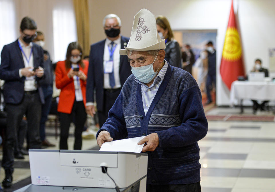 A man in a Kyrgyz national hat casts his ballot at a polling station during the referendum in Bishkek, Kyrgyzstan, Sunday, April 11, 2021. Voters in Kyrgyzstan cast ballots Sunday on whether to approve a new constitution that would substantially increase the president's powers. The Sunday referendum comes three months after Sadyr Zhaparov was elected president, following the ouster of the previous president amid protests, the third time in 15 years that a leader of the Central Asian country had been driven from office in a popular uprising. (AP Photo/Vladimir Voronin)