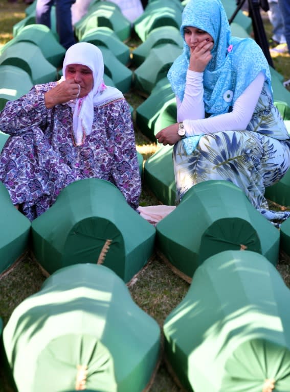 Bosnian women offer prayers near the caskets of 71 newly-identified victims of the 1995 Srebrenica massacre, at a burial ceremony in July