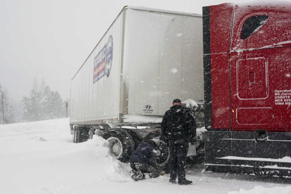 Chains are installed on a big rig’s tires during a storm, Saturday, March 2, 2024, in Truckee, Calif. A powerful blizzard howled Saturday in the Sierra Nevada as the biggest storm of the season shut down a long stretch of Interstate 80 in California and gusty winds and heavy rain hit lower elevations, leaving tens of thousands of homes without power.