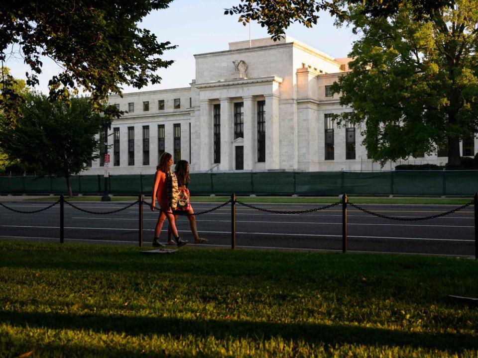  Pedestrians walk past the U.S. Federal Reserve in Washington, DC.