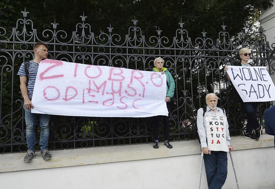Protesters with banners calling on Justice Minister Zbigniew Ziobro to quit over allegations that his deputy encouraged an online hate campaign against defiant judges in Warsaw, Poland, Wednesday, Aug. 21, 2019. The deputy, Lukasz Piebiak, has resigned over the allegations but said they were libel that he will take to court. The banner reads "Ziobro Must Go". (AP Photo/Czarek Sokolowski)
