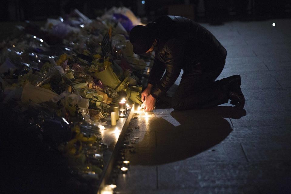 Man lights candles during a memorial ceremony for people who were killed in a stampede incident during a New Year's celebration on the Bund, in Shanghai