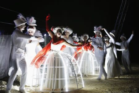 Performers acts on stage during a dress rehearsal of Giuseppe Verdi's opera "La Traviata" at the foothill of Masada, an ancient Jewish mountaintop fortress near the Dead Sea in southeast Israel June 10, 2014. REUTERS/Amir Cohen